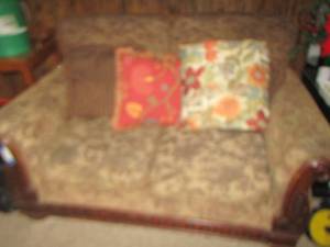 lot 8 image: Solid wood dark brown love seat with various throw pillows