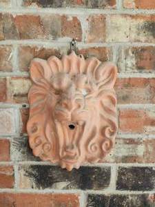 lot 202 image: Clay lionhead on wall by door