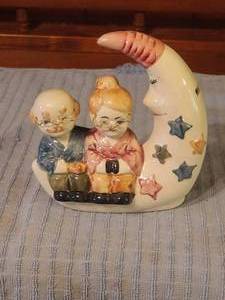 lot 263 image: Elderly couple sitting on the moon figure