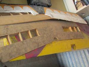 lot 12 image: Random size model airplane wings, 1 purple & yellow- 1 wooden 1 tan and another
