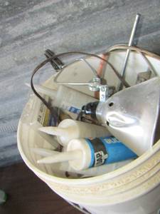 lot 37 image: White 5 gallon bucket of caulking tubes- work light- scrappers