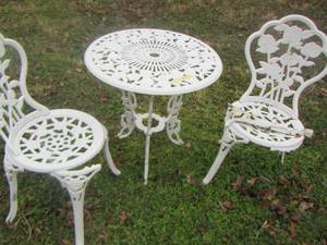 lot 557 image: White iron table and chairs outdoor furniture, one chair needs leg repair