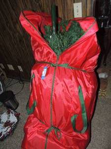 lot 606 image: Green Christmas tree in bag with tree stand  approx. 8ft