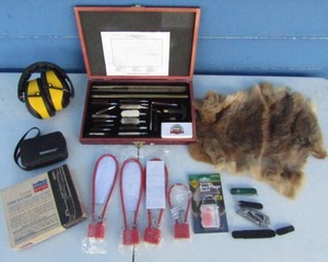 lot 12 image: Firearm accesories lot, including gun cleaning kit, ear plugs and headset, Gerber aircraft aluminum folding knife, Wenger Swiss Army knife, gun cable locks, Tasco binoculars, and rabbit fur