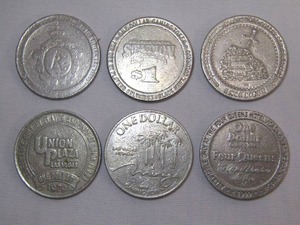 lot 33 image: Six casino tokens, including Four Queens Hotel one dollar gaming token, Las Vegas token, Excalibur, Colorado Central Station, Union Plaza