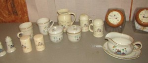 lot 25 image: International stoneware serving pieces- 2 hot plates- S & P shaker set qty 3- gravy boat with plate- 2 creamers- 1 water picture- 2 canisters with lids
