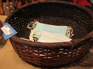 lot 894 image: double handled wicker basket, random new face mask in basket