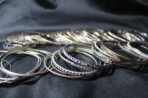 lot 224 image: (50) SILVER TONE metal, aluminum, and plastic bangle bracelets. Assorted styles.