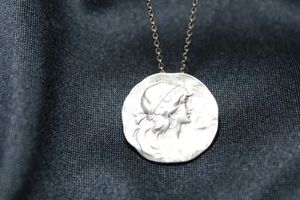 lot 27 image: Sterling Silver faux coin pendant necklace. Marked 925 on spring ring and silver on pendant. Pendant features a cameo style portrait. 16L. Pendant is 1W. 4.8 gr approx
