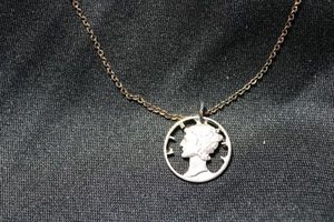 lot 47 image: Sterling Silver laser cut 1943 Mercury dime (Lady Liberty wearing Phrygian winged cap, 90% Silver) pendant necklace. 16L. Marked 925 on spring ring clasp. 3.8 gr approx