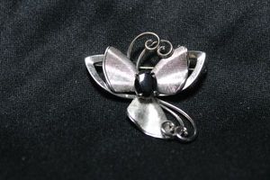 lot 36 image: Signed Sterling Silver Carl Art flower brooch with Hematite center stone. 2W approx. Marked sterling with the Carl Art hallmark. 8.5 gr approx