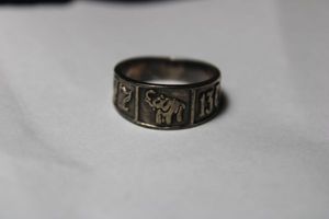 lot 57 image: Sterling Silver Taxco Good Luck band ring featuring lucky symbols (horse shoe, 4-leaf clovers, elephant with raised trunk, etc.). Marked 925 Mexico TB-169. Size 8. 5.5 gr approx