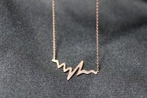 lot 85 image: Sterling Silver gold vermeil (gold over sterling) cable link chain necklace with incorporated heartbeat pendant. 14L with 2 extender. Marked 925 MIDAS Turkey near lobster clasp and 925 on clasp. 2.0 gr approx