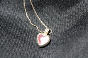 lot 98 image: Sterling Silver box chain 18L necklace with pink heart faux cats eye pendant. Marked 925 on spring ring clasp. Pendant unmarked but does have hallmark inside.