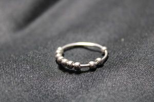 lot 104 image: Sterling Silver ring with floating sterling beads. Marked S925 inside. Size 7.