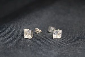 lot 108 image: Sterling Silver poststud square prong set CZ earrings. Marked 925 SUN inside one butterfly back.