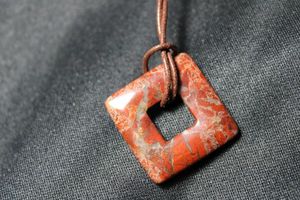lot 113 image: Sterling Silver cord necklace with carved square red Jasper or Agate pendant. (has crack). Marked 925 lobster clasp. 22L