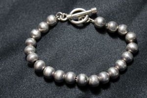lot 117 image: Sterling Silver silversmith artisan created ball bead bracelet on silver wire. 8.5L. Marked 925 on toggle clasp with dumb bell ends. 25.3 gr approx