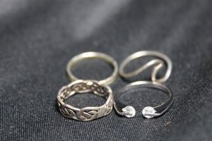 lot 123 image: (4) Sterling Silver rings. All marked 925. Celtic ring is size 6. Crystal suspension ring is size 7. Remaining are 6 and 6.5.