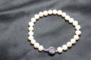 lot 150 image: Helzberg Cultured freshwater potato pearl bracelet. Marked PG PM. Individually knotted. Push in safety clasp decorated with I Am Loved (A Helzberg jewelry collection)