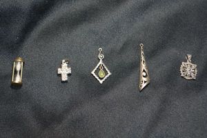 lot 128 image: (5) Sterling Silver pendants. All marked 925. Includes fully functioning hourglass with sand, marcasite, quartz cross (tested), modernist tube pendant and Iolite dangle.