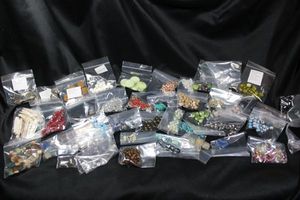 lot 353 image: (30) Glass and other unique bead selection. Includes Kintsugi style moss green w gold accents, Kanji letter ball beads, Snake Skin imprint, Egyptian Beetle, German Black Forest wood beads, and more.