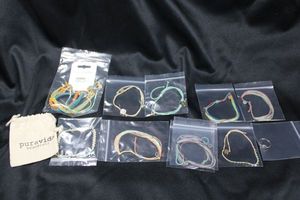 lot 356 image: (15) Signed artisan made Pura Vida bracelet selection. 14 bracelets and a ring (size 8.5 approx). All are marked and have the jewelry hang tags.