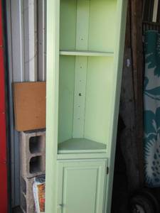 lot 83 image: light green color corner shelf 72 tall, has 2 shelves and 1 bottom door