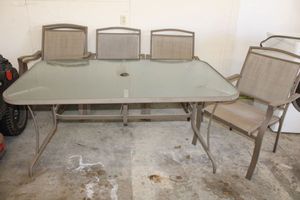 lot 30 image: Glasstop Patio table with 5 chairs. Features an umbrella hole on table and all chairs are armchairs.