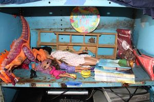 lot 60 image: Dolls, dinosuar toy, Curious George yo-yo, wall shelf, books and wigs