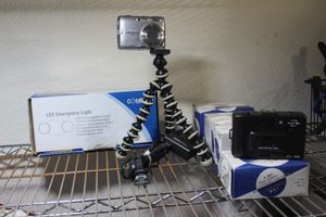 lot 56 image: Emergency Lights in orginal package, Nikon camera and several 34mm cameras in orginal boxes and a adjustable table top tripod