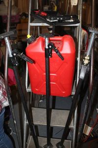 lot 89 image: Three Load lock Poles, 5 Gallon Gas can, and Bully auto quick jumper