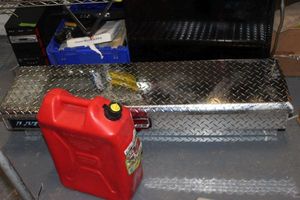 lot 90 image: Lund Silver Diamond Plate Truck Tool Box, unused, and 5.3 Gal. Gas Can