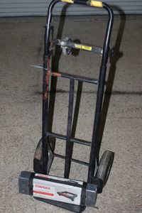 lot 134 image: Hand dolly that lays down to make cart, and unused portable furniture Dolly