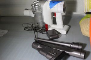 lot 129 image: Hand Held Dyson Max with Charger Cord and Attachments (see Photos) FOR PARTS ONLY DOES NOT CHARGE