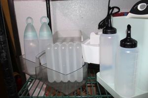 lot 421 image: Tupperware Bread Storage, M Design Storage Bins and Organizers, Cabinet Shelf and Oxo Vinger and Oil bottles, Egg trays