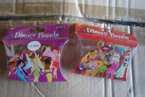 lot 223 image: NEW- DISNEY PARKS, DISNEY BANDS BRACELETS SERIES 1, FAIRIES-6-Packs Of 12-Bands MUPPETS-6-Packs Of 12-Bands