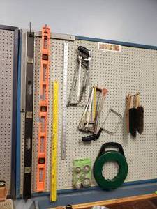 lot 1512 image: Contents On Wall.  Levels, Hacksaws, Fish Tape & More
