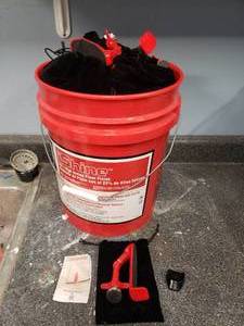 lot 1549 image: 5 Gallon Bucket Full of Doorjammer Door Safety Locks.  Approx 46 Pieces