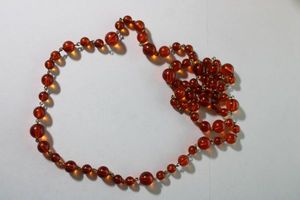 lot 124 image: Signed Bill Blass (1922-2002) dark red wine Autumnal acrylic bead necklace with metal connectors. 34L with 3 extender. Has BB hang tag. Lobster clasp.