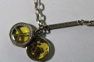lot 125 image: Signed Brighton vintage iconic iDream peace globe necklace with Peace starts within bar. 16L with 3 extender. Has script B heart hang tag.