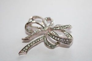 lot 137 image: Signed Carolee art deco ribbon bow rhinestone broochpin. 3W x 2.5H. Marked Carolee on reverse.