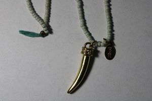 lot 168 image: Signed beaded necklace with gold plated and crystal adorned horn pendant. Marked with Express hang tag. 26L.