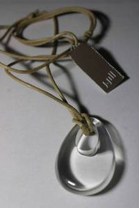 lot 192 image: Signed J Jill (Berkshires, MA 1959 - ) clear glass teardrop pendant on adjustable leather cord 22L necklace with retail tag.