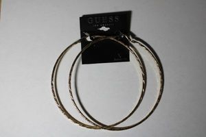 lot 194 image: Signed Guess textured gold tone hoop 4W earrings on retail hang card.