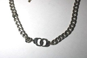lot 209 image: Novelty heavy Cuban link necklace with interlocking handcuff pendant. Lobster clasp. 16L with 3 extender.