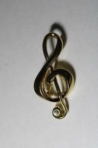 lot 224 image: Signed Liz Claiborne music treble note gold plated broochpin with crystal accent. Marked LC on reverse. 2L