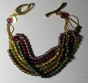 lot 225 image: Signed Liz Claiborne metal multi strand beaded bracelet. Toggle clasp. Has LC hang tag. 7L