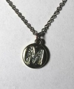 lot 226 image: Signed Liz Claiborne crystal M monogram disc pendant necklace. Has LC hang tag. 16L with 3 extender.