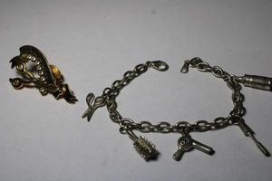 lot 233 image: Cable chain link silver plate 7L bracelet with hair stylist charms. Includes scissors, hair dryer, hair spray, styling wand and brush. Lobster clasp. Also includes a gold plated #1 Hairdresser pin. 2L